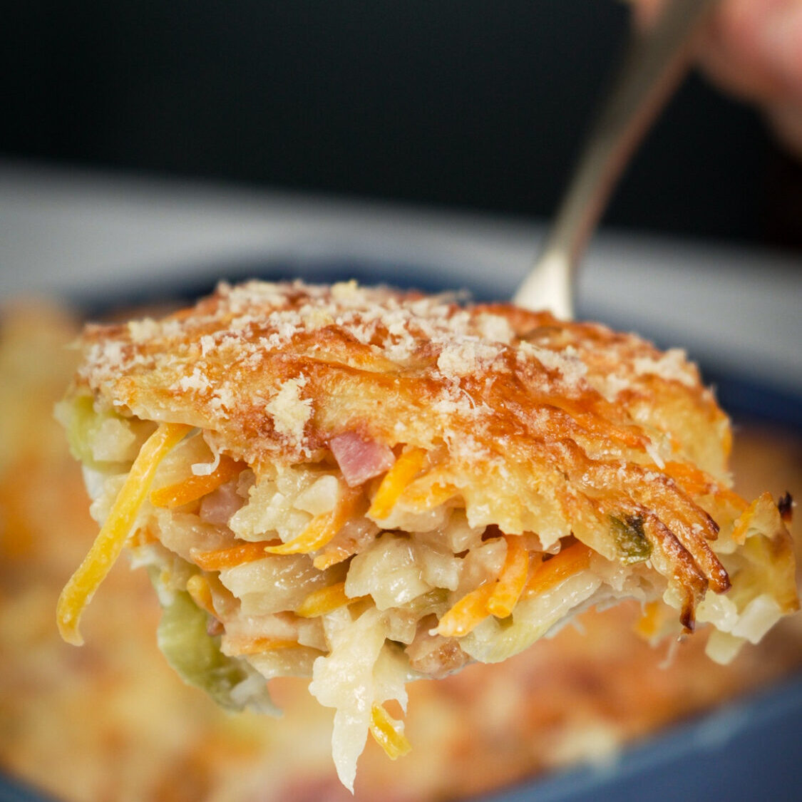 Close-up de uma porção de bacalhau espiritual com crosta dourada e queijo